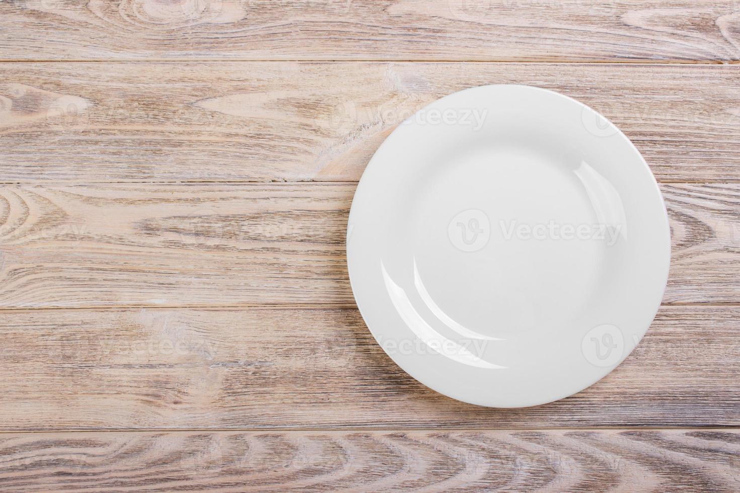 Empty white plate on wooden table. Template for your design. photo