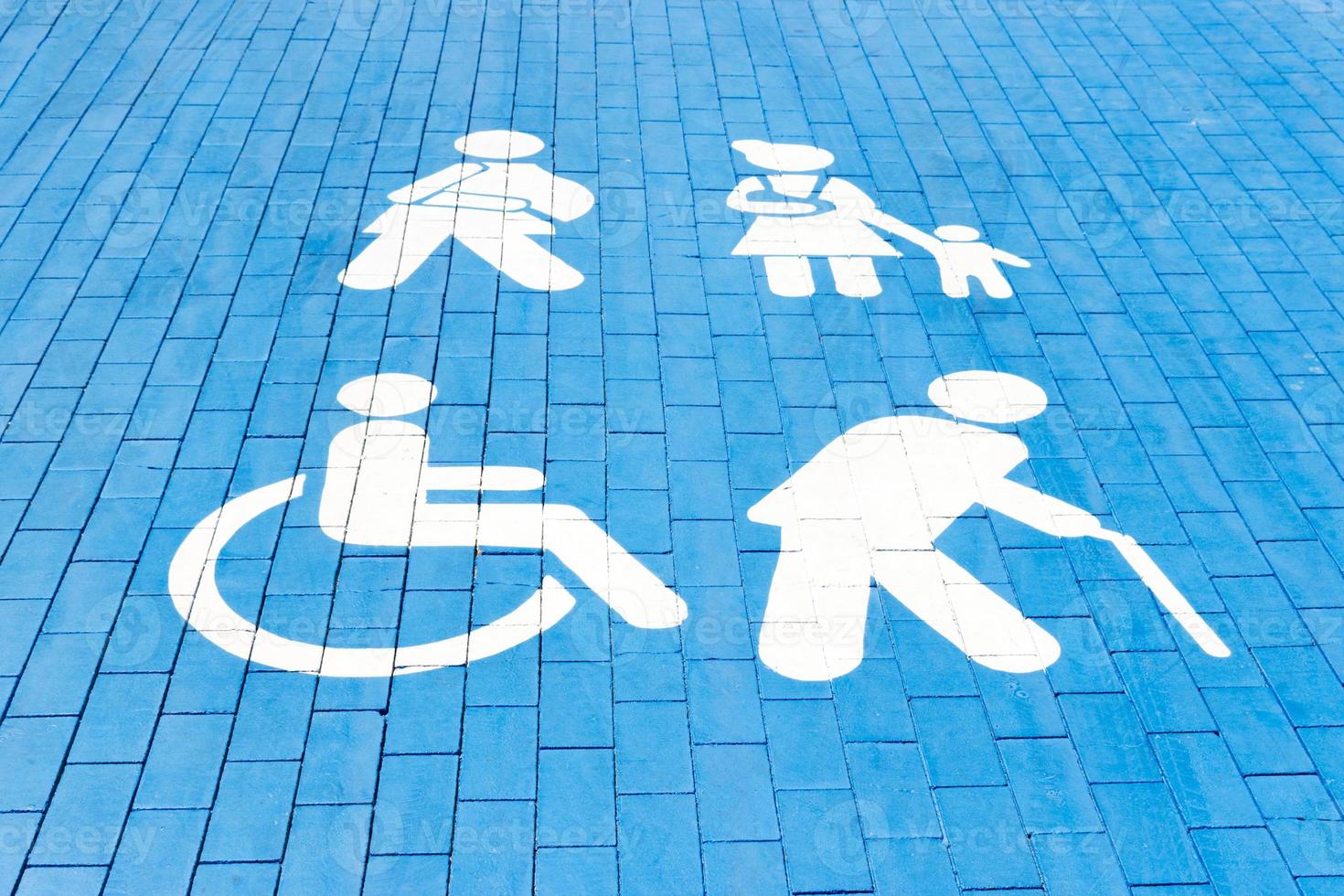 Handicapped parking spot, mom with child, elderly person and man with plaster. blue square on asphalt photo