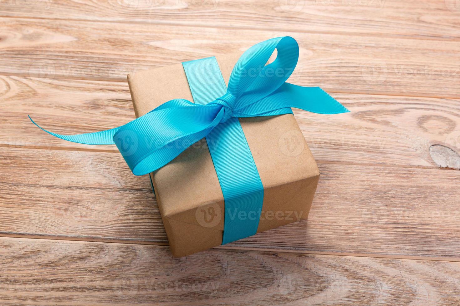 One gift box with blue ribbon wooden table background. top view photo