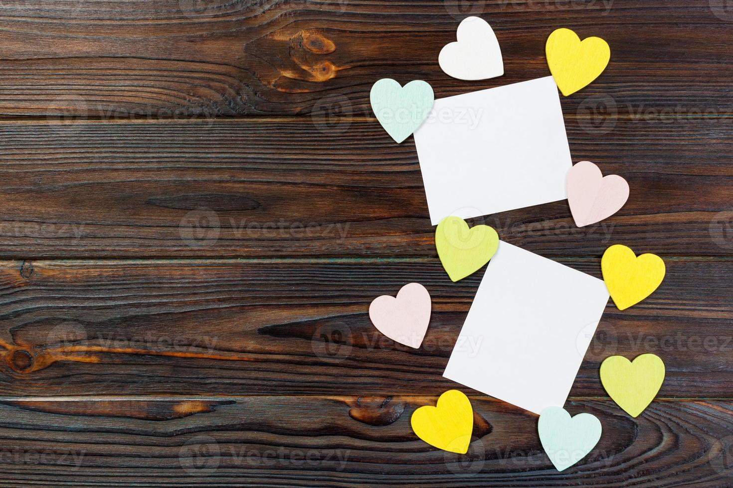 Empty paper over wooden background with colorful heart on valentines day photo