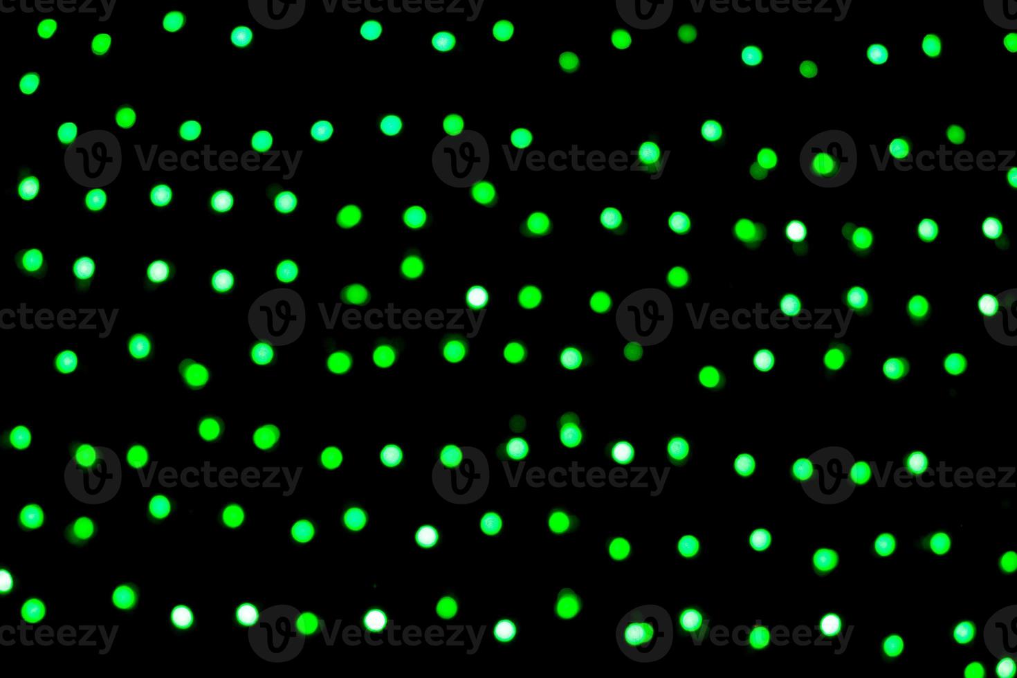 Unfocused abstract green bokeh on black background. defocused and blurred many round light photo