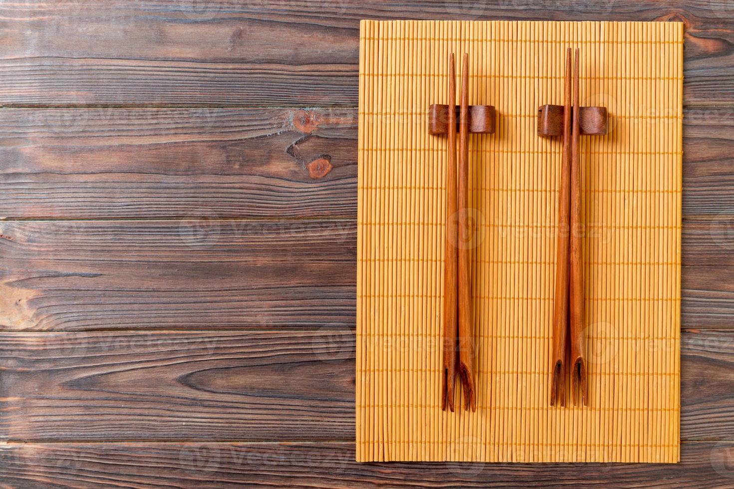 two sets of sushi chopsticks on wooden bamboo background, top view photo
