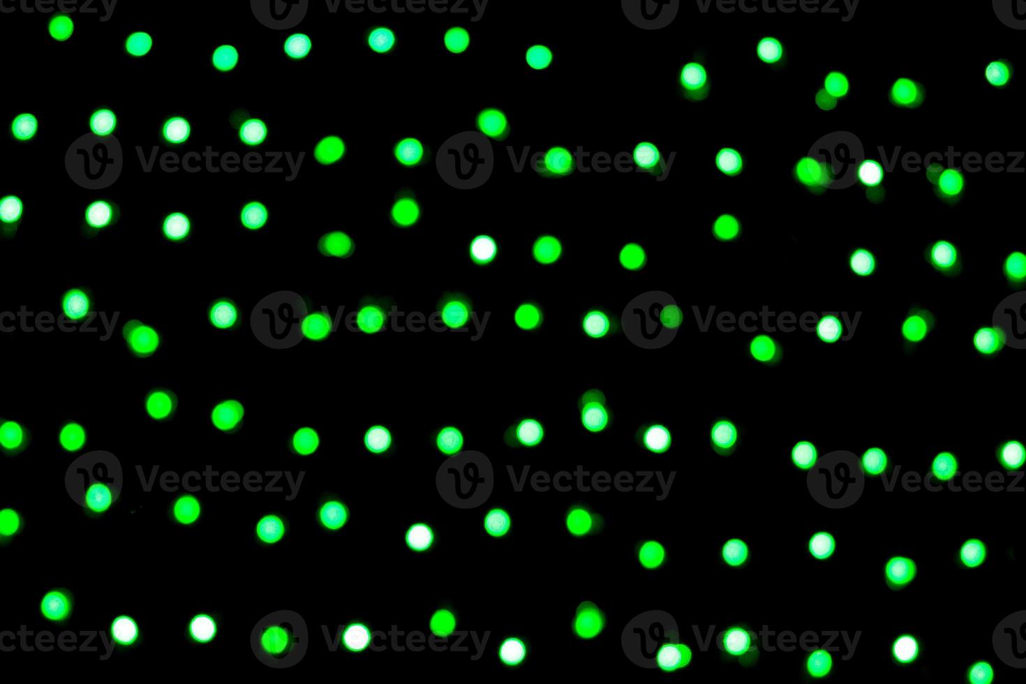 Unfocused abstract green bokeh on black background. defocused and blurred many round light photo