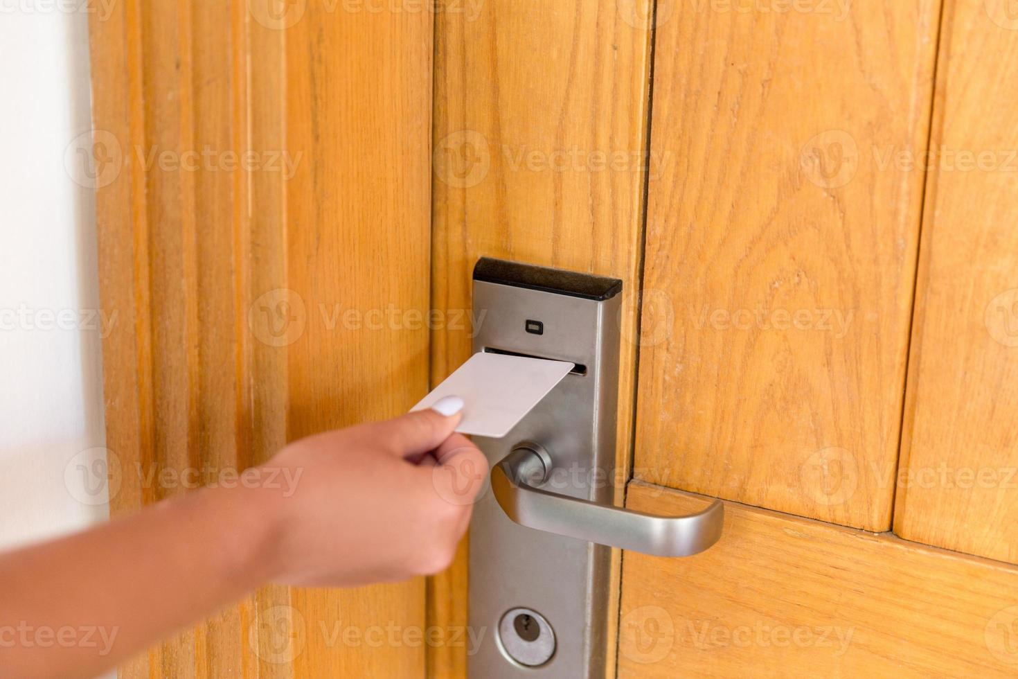 Woman hand with keycard in the electronic lock. female hand hold key card and open electronic lock door photo