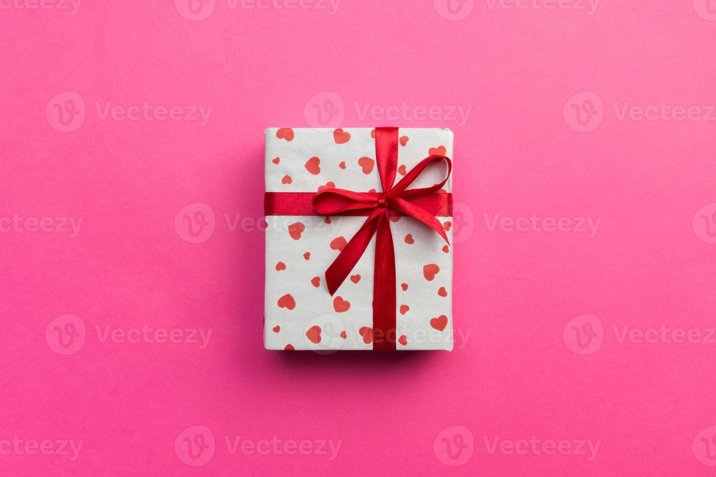 Background with gift box and hearts on pink Background. Top view with copy space for text photo