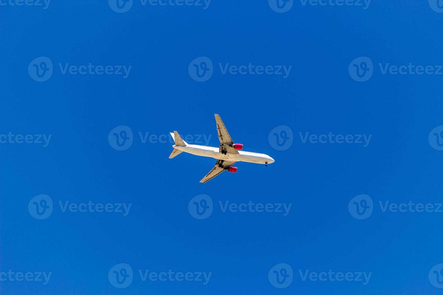 A plane flying in the blue sky without white clouds photo