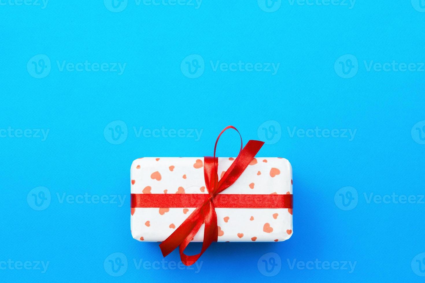 Gift box with red hearts on blue background. top view with copy space photo