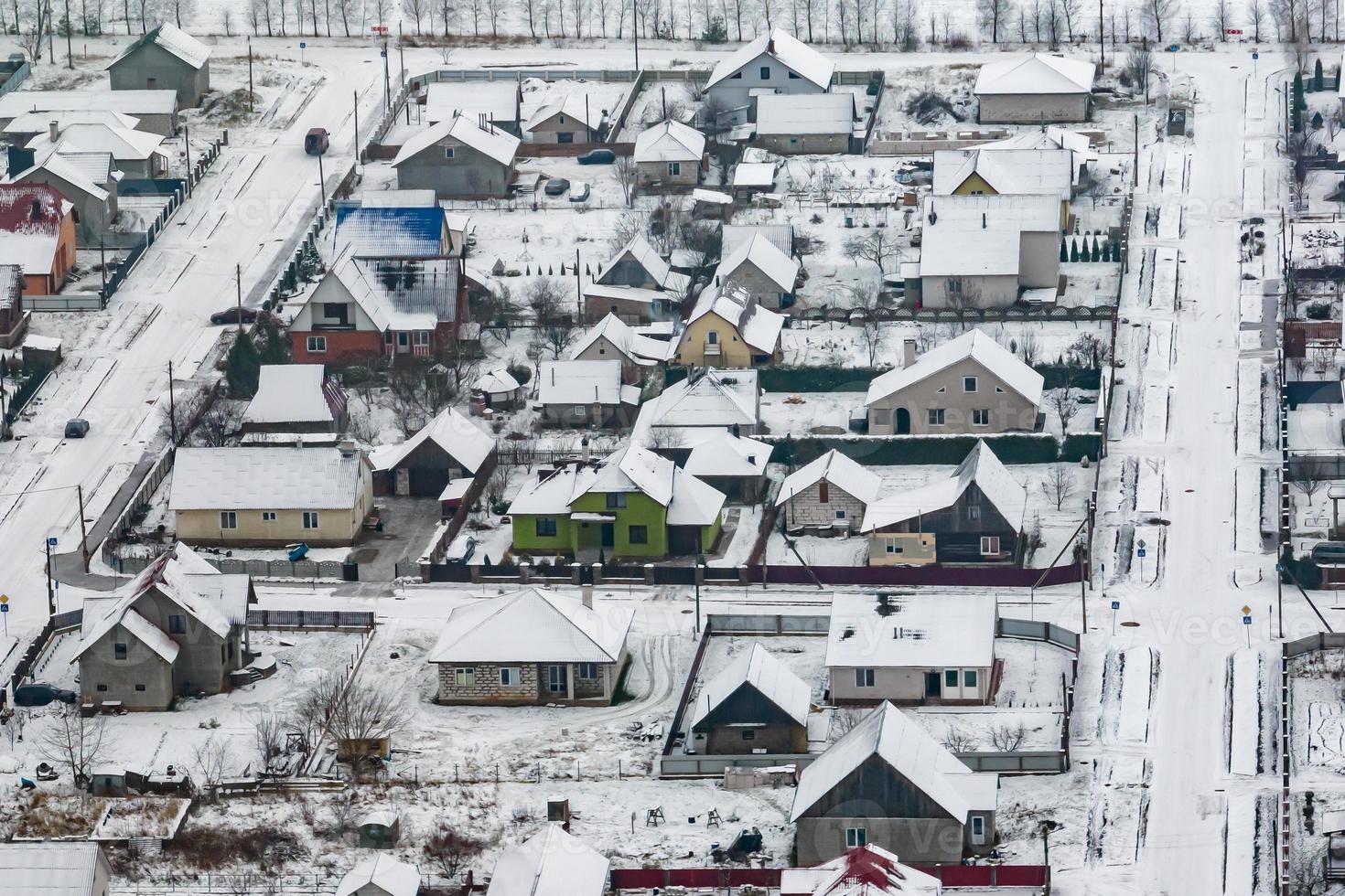 aerial panoramic winter view of village with houses, barns and gravel road with snow photo