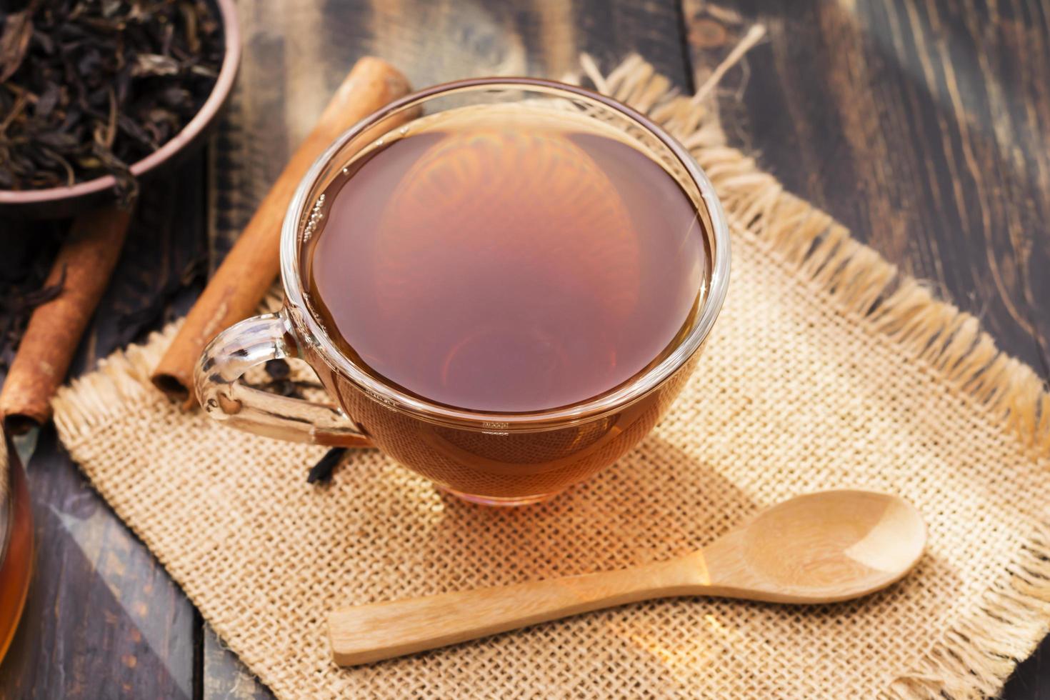 Close-up shot of a cup of hot tea or coffee placed on a desk or a table, drinking coffee by the window at work or at home, at sunset or in the morning. photo