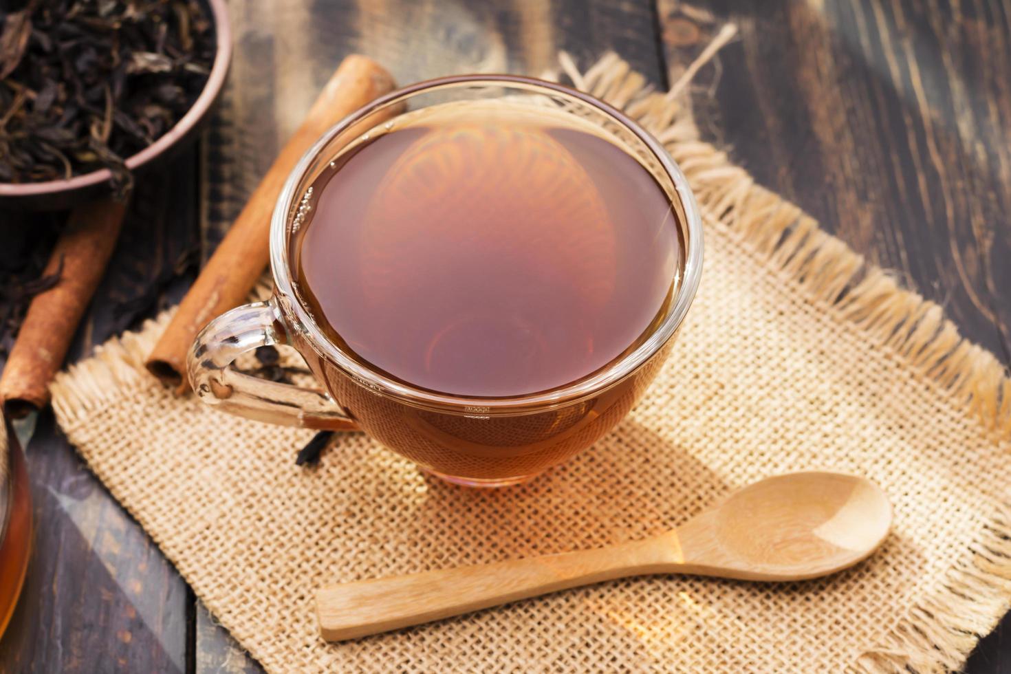 primer plano de una taza de té o café caliente colocada sobre un escritorio o una mesa, tomando café junto a la ventana en el trabajo o en casa, al atardecer o por la mañana. foto