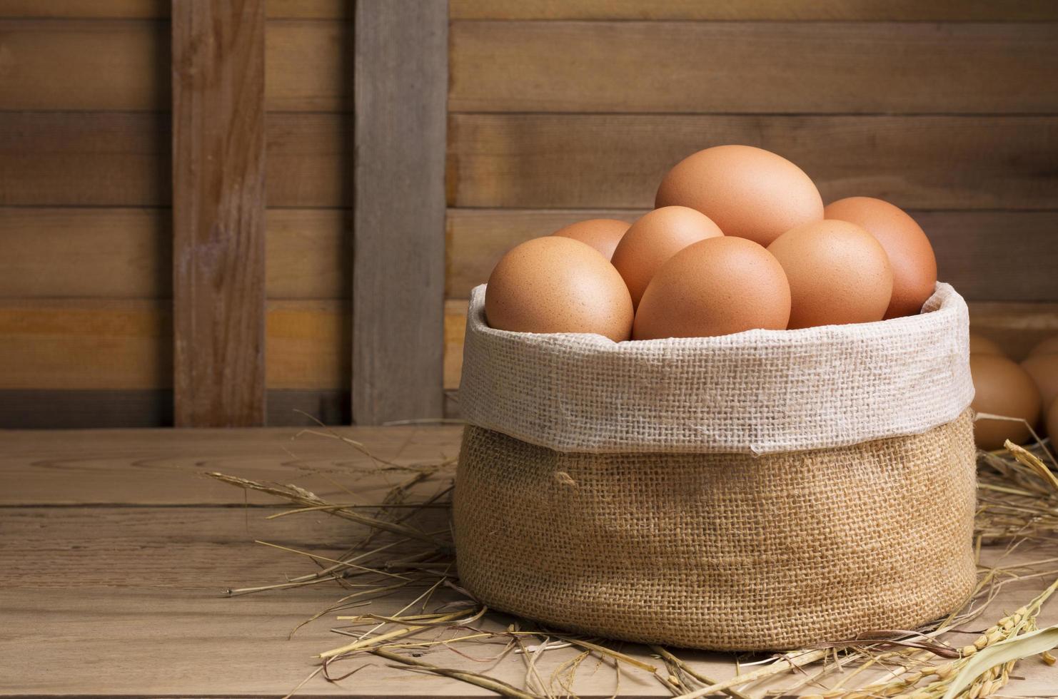 Fresh organic chicken eggs from the farm on a rustic wooden table. photo