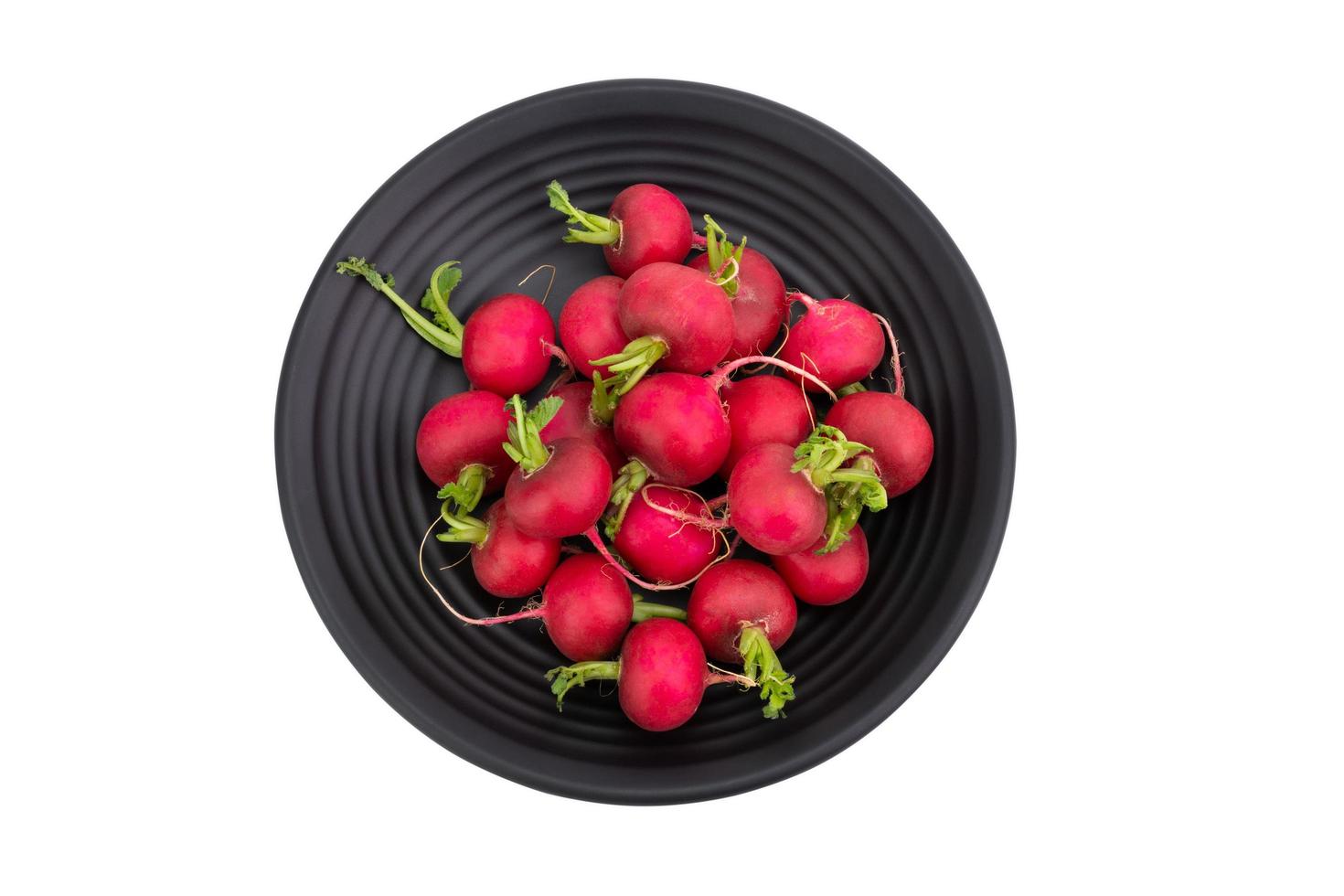 Red or purple radishes are placed on a black plate. Organic salad, healthy natural food ingredients. isolated on white background, top view - clipping path photo