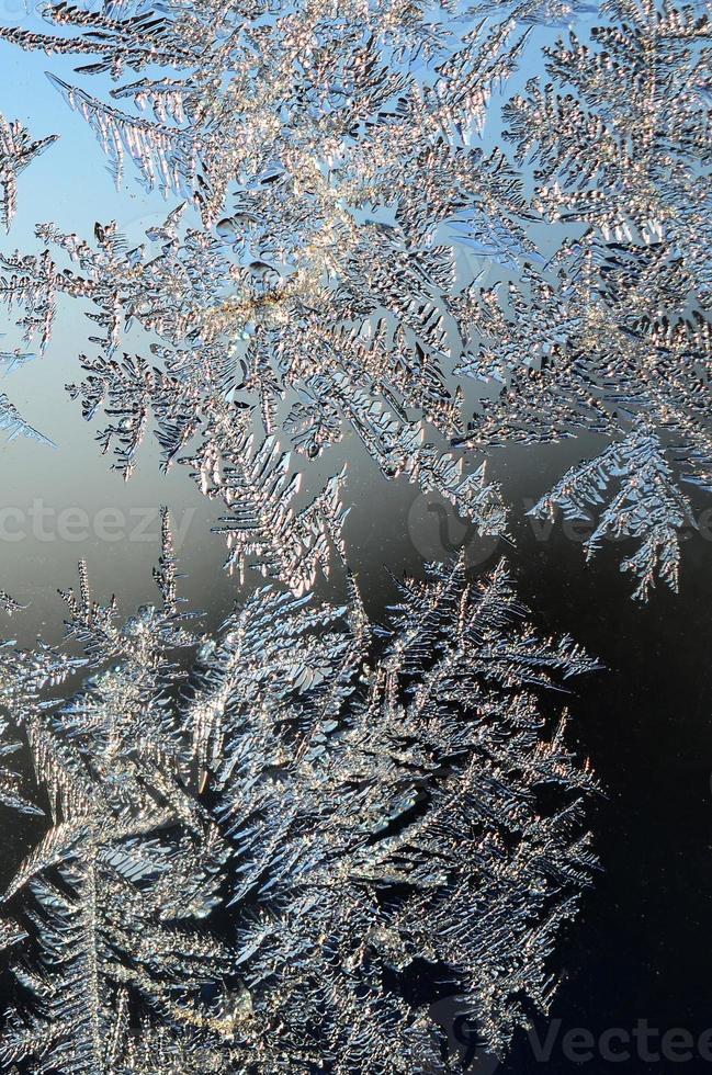 Snowflakes frost rime macro on window glass pane photo