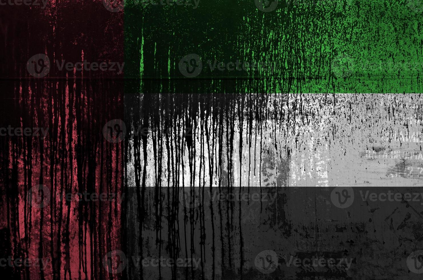 United Arab Emirates flag depicted in paint colors on old and dirty oil barrel wall closeup. Textured banner on rough background photo