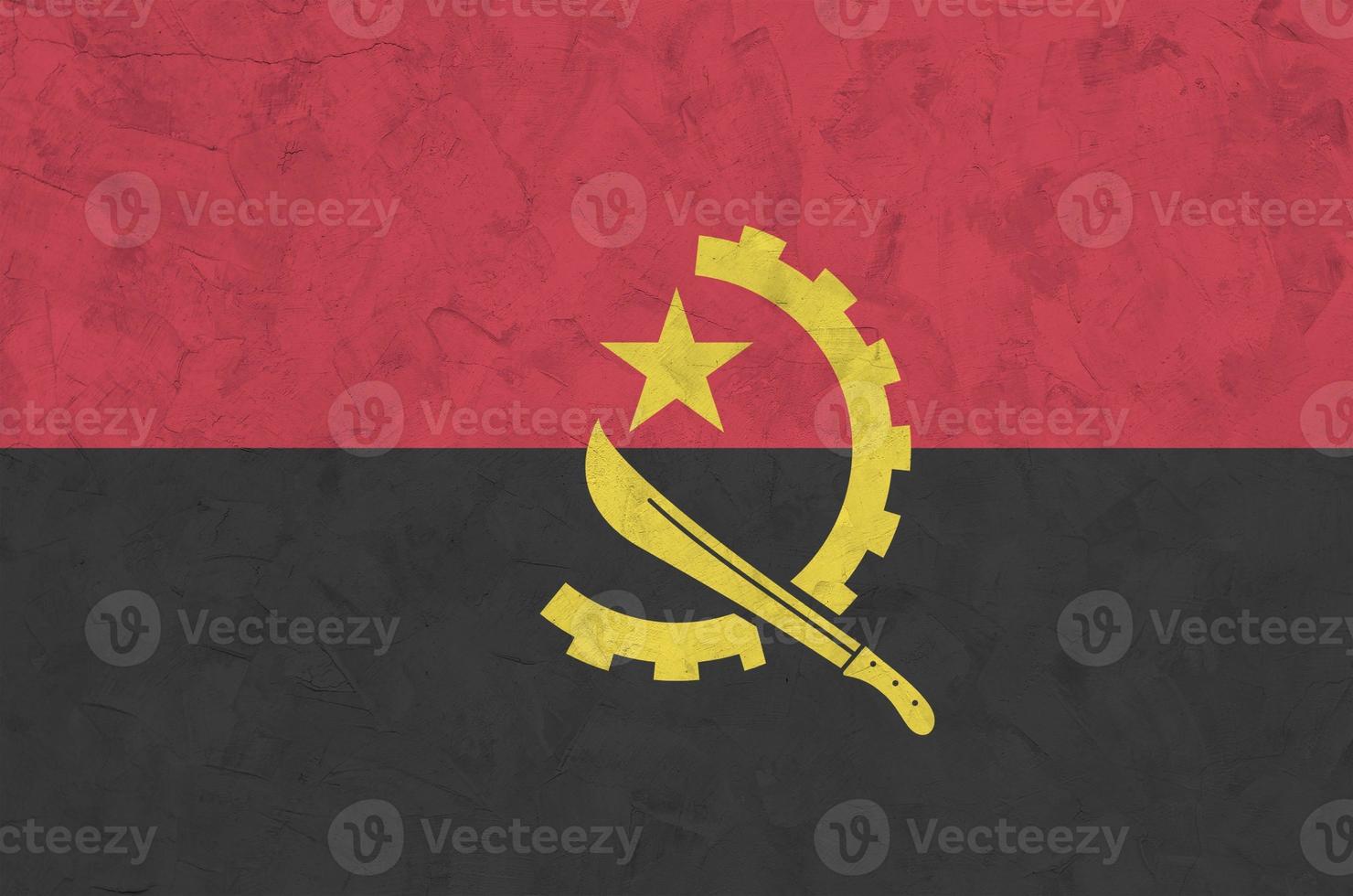 Angola flag depicted in bright paint colors on old relief plastering wall. Textured banner on rough background photo