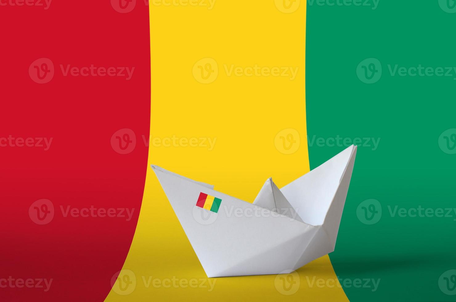 bandera de guinea representada en primer plano de barco de origami de papel. concepto de artes hechas a mano foto