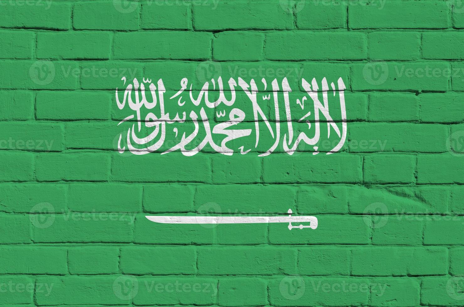 Saudi Arabia flag depicted in paint colors on old brick wall. Textured banner on big brick wall masonry background photo