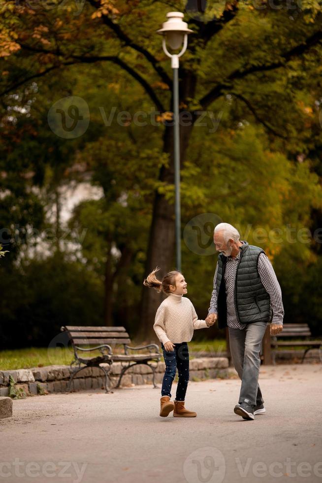 abuelo pasando tiempo con su nieta en el parque el día de otoño foto