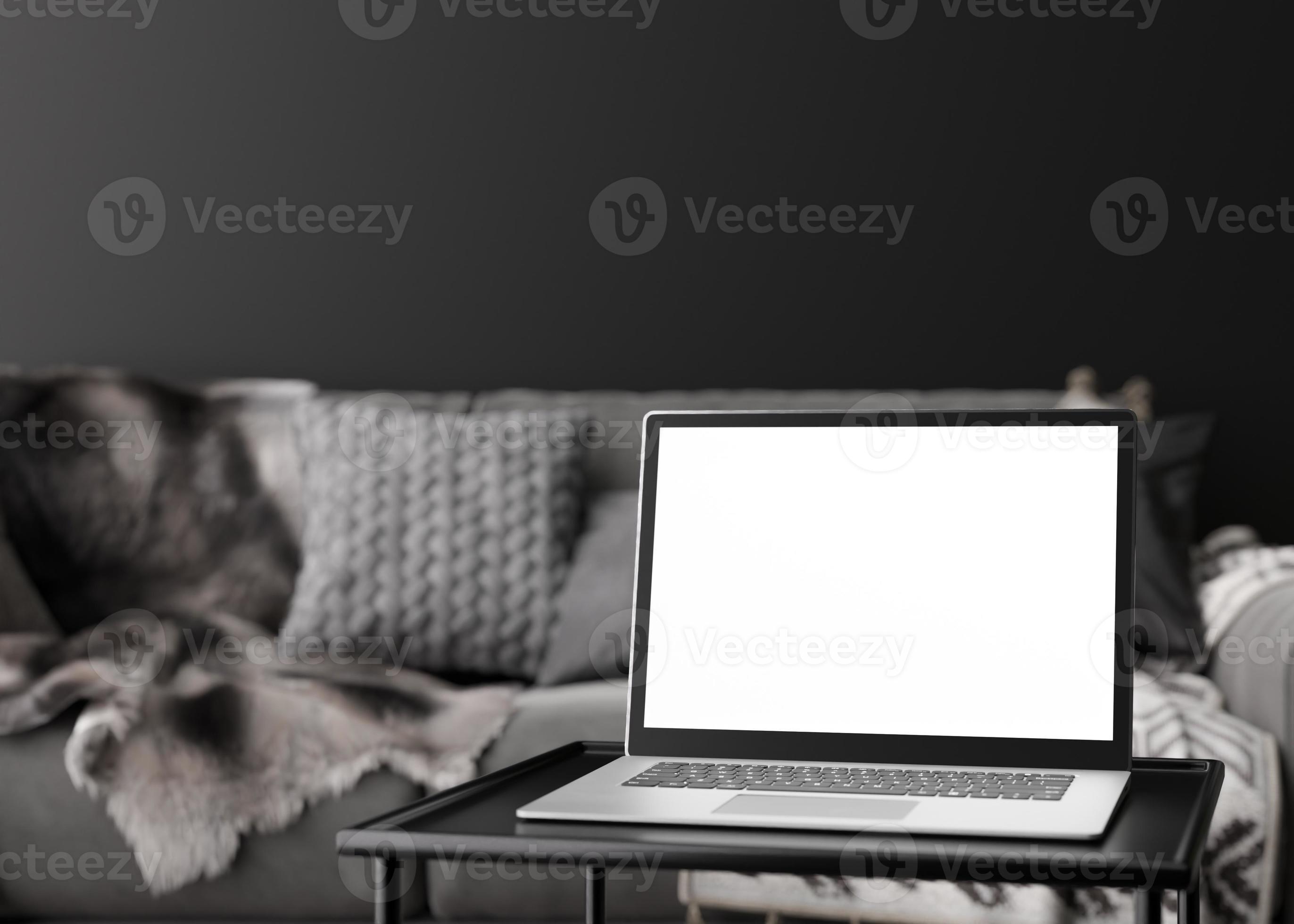 Laptop with blank white screen, on black table at home. Computer mock