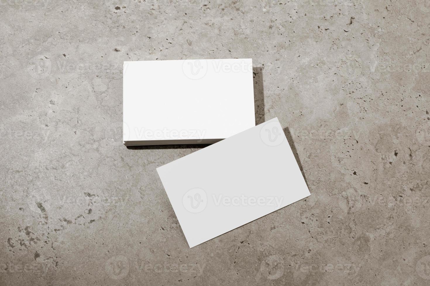 Blank white business cards on rough concrete surface. Mockup for branding identity. Possibility to show both sides of card. Template for graphic designers. Free space, copy space. photo