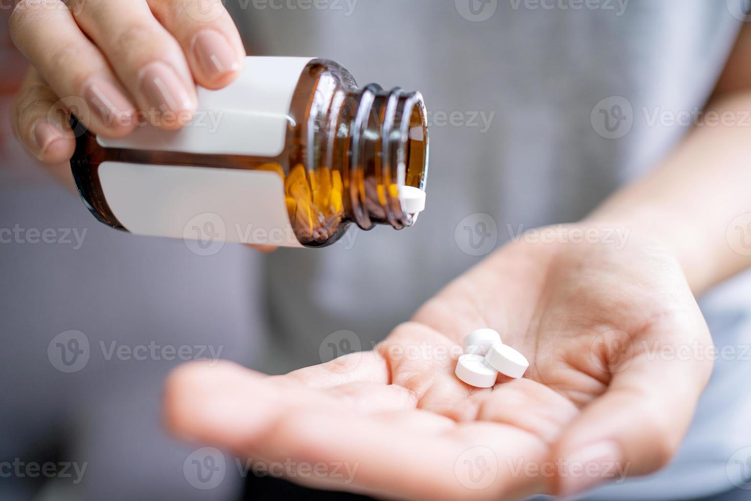 Woman holding pills on hand. Medicine and health care concept. Healthy lifestyle, medicine, nutritional supplements and people concept photo