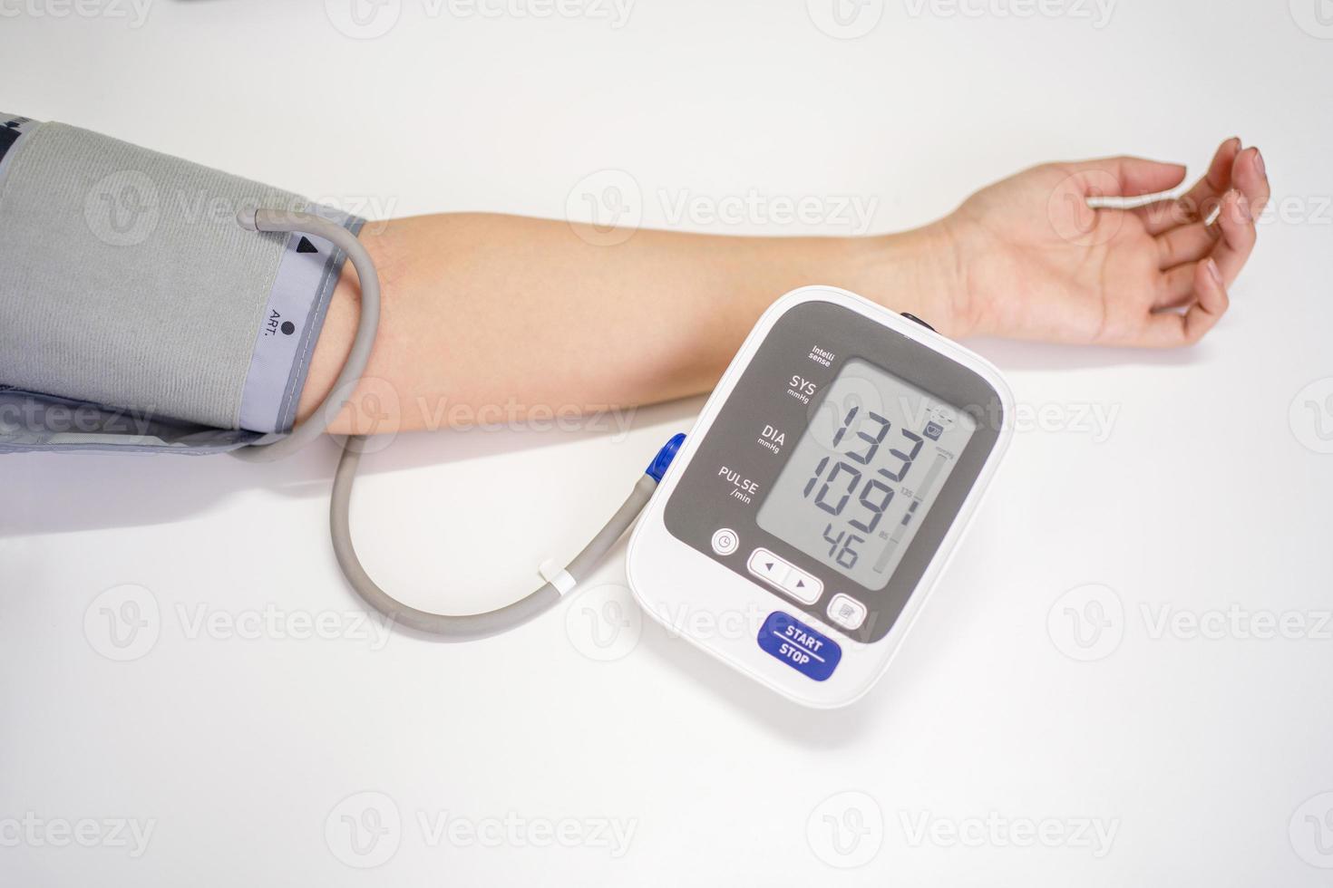 la mujer mide la presión arterial, con espacio de copia sobre fondo blanco foto