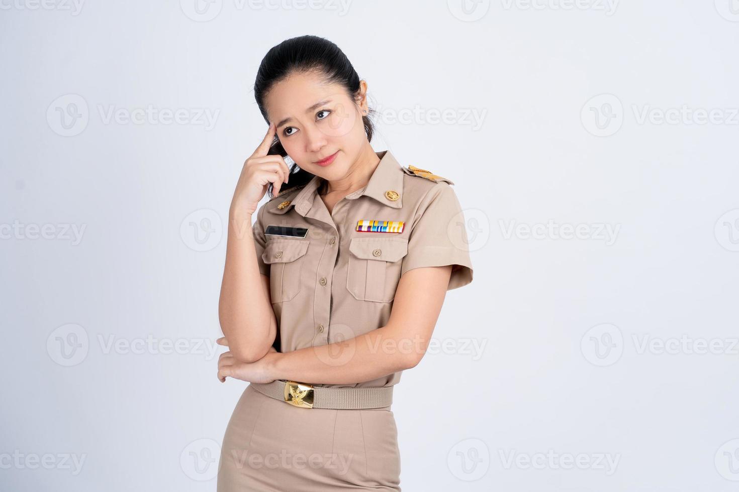 Asian woman thinking about something in brown work clothes She stands isolated on a white background. photo