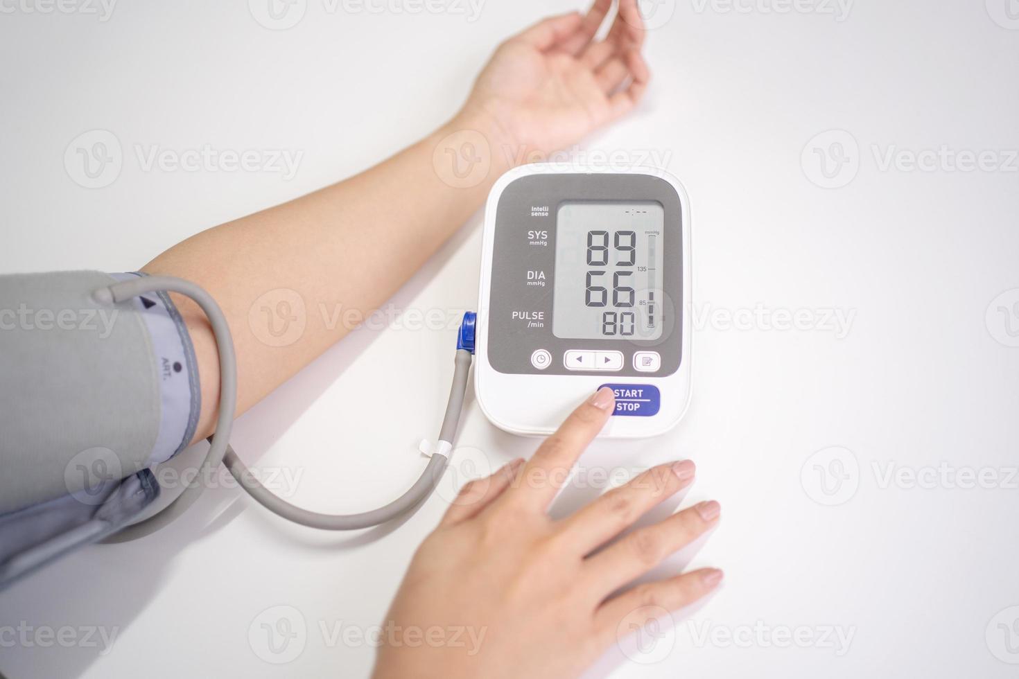 Female measures her blood pressure. photo