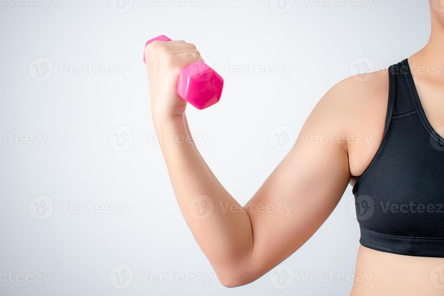 Women lifting dumbbells to train arm muscles at home. Concept of exercise and muscle training. Isolated background. photo