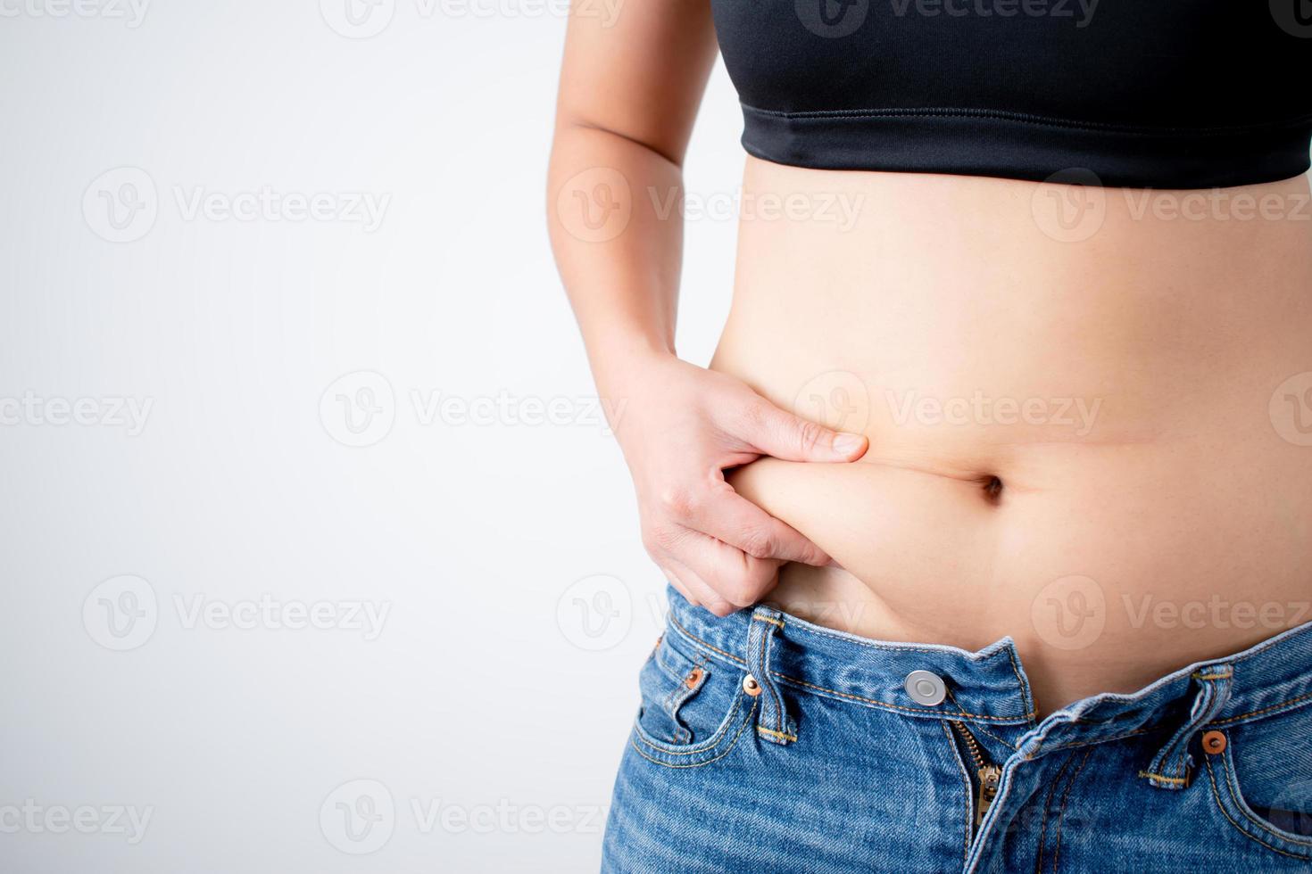 Close up of a woman's hand that grabs belly fat. With copy space photo