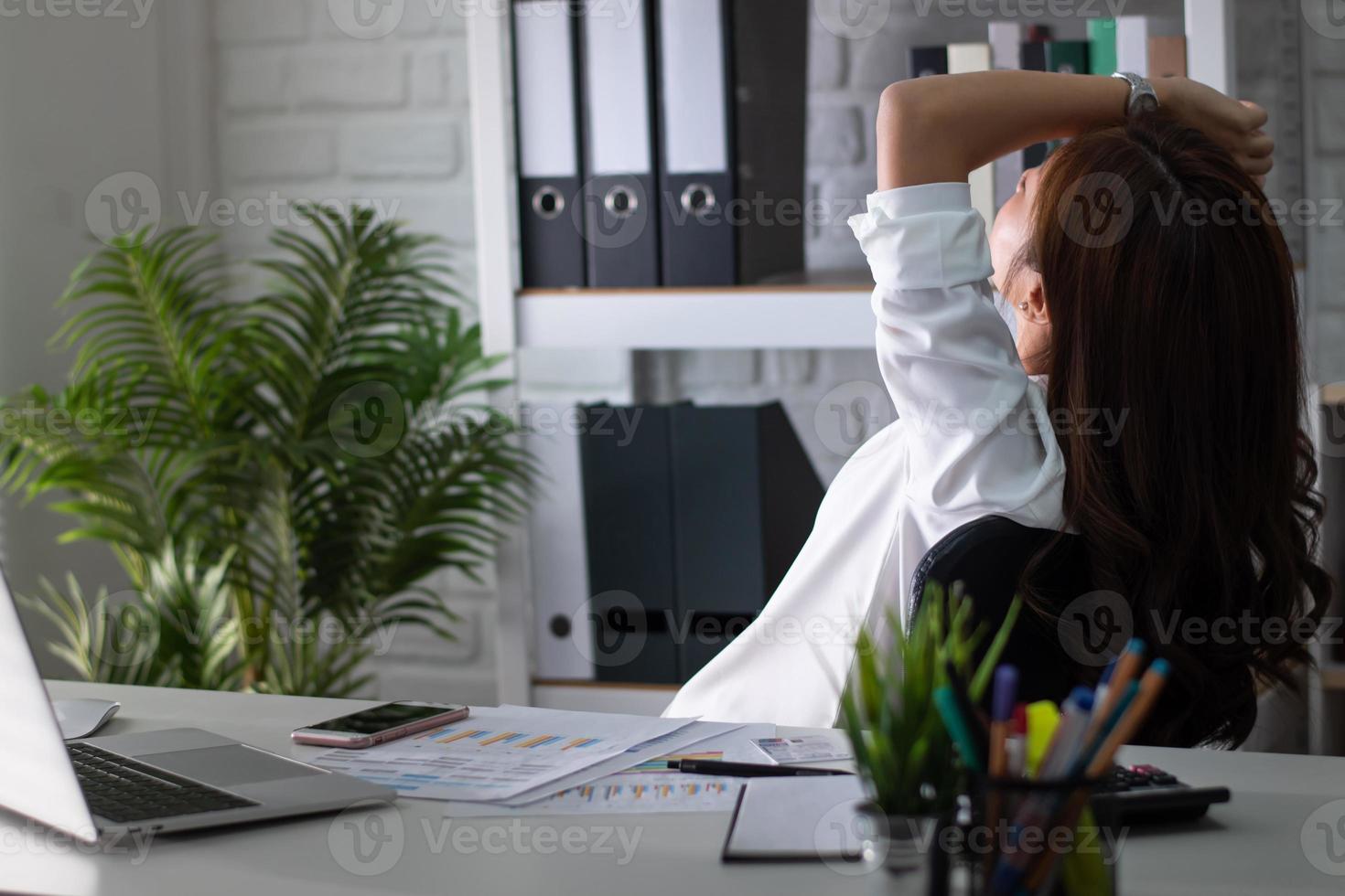 Asian women are tired and stressed about work. She is in the office. photo