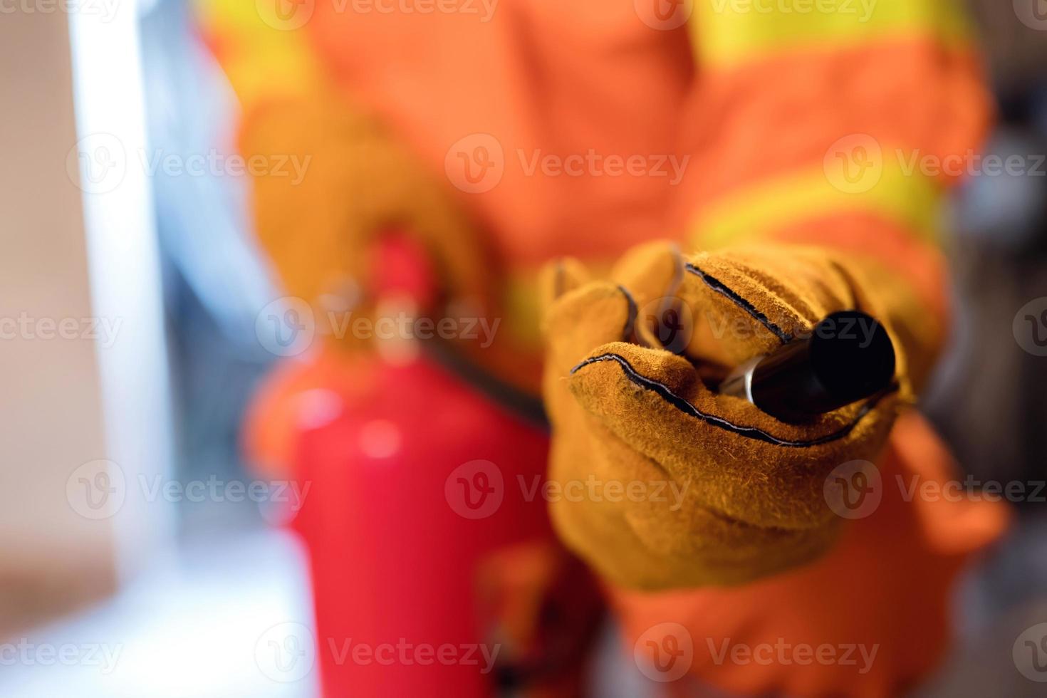 Focus on the fire extinguisher, the man carried the fire extinguisher to put out the fire in the building. photo