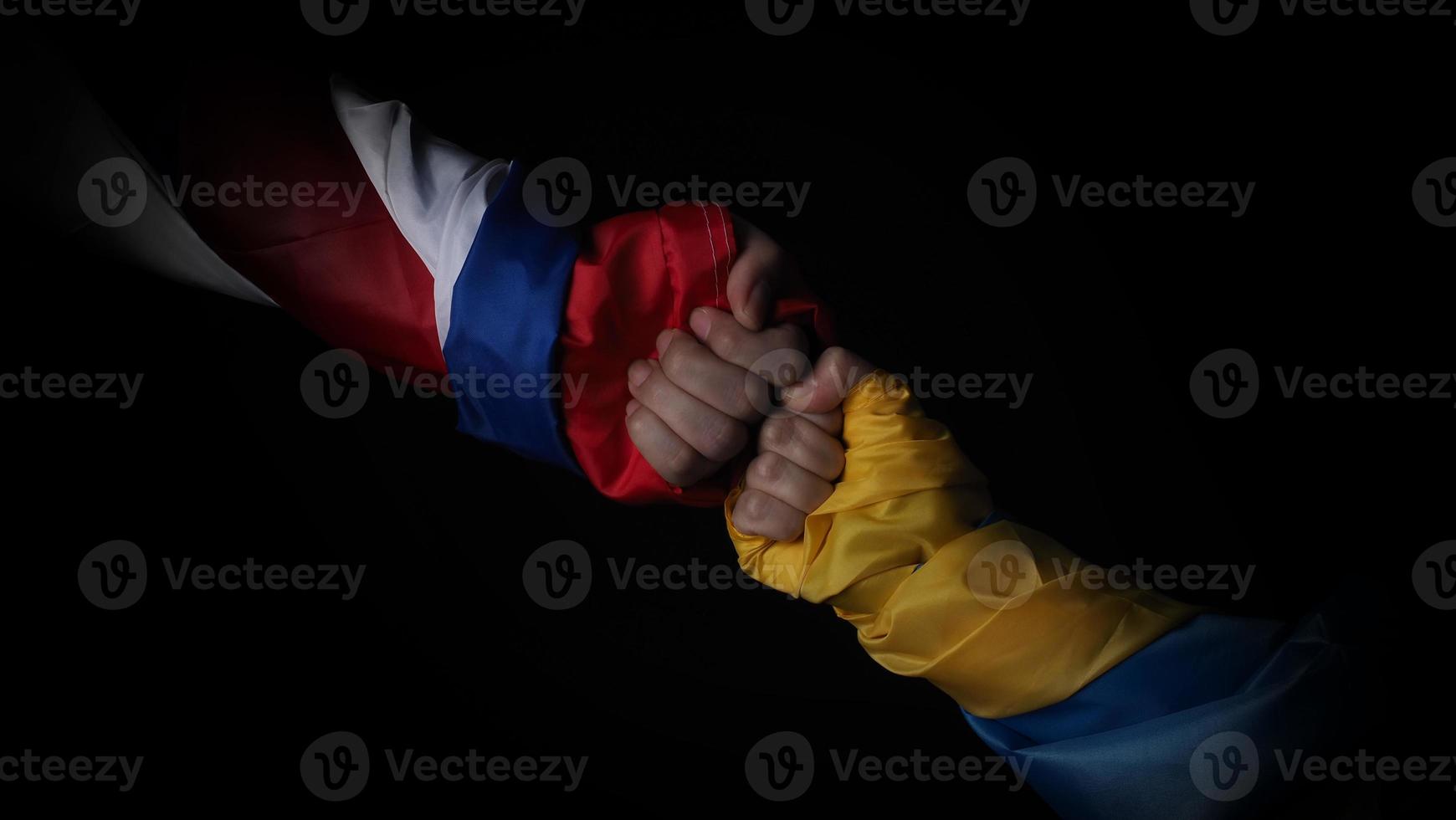 bandera rusa y bandera de ucrania en las manos que muestran el símbolo de la guerra de lucha foto