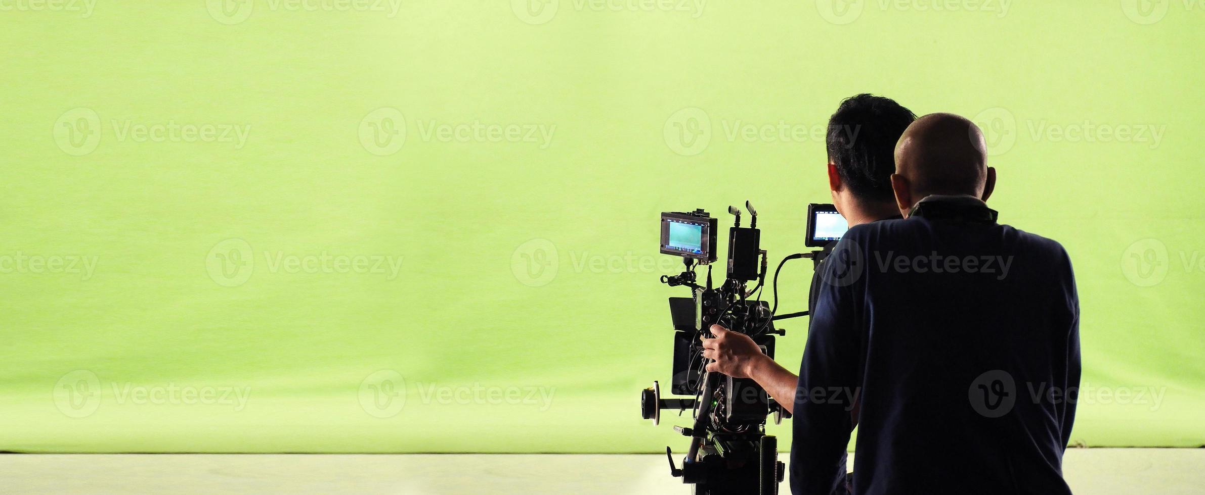 cámara y estudio de pantalla verde en vista panorámica y hombre trabajando o disparando o grabando o filmando. foto