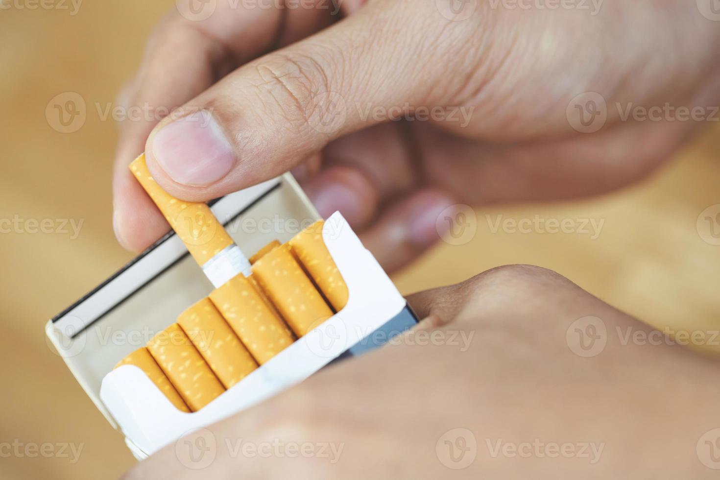 close up man hand holding peel it off cigarette pack prepare smoking a cigarette. Packing line up. photo filters Natural light.