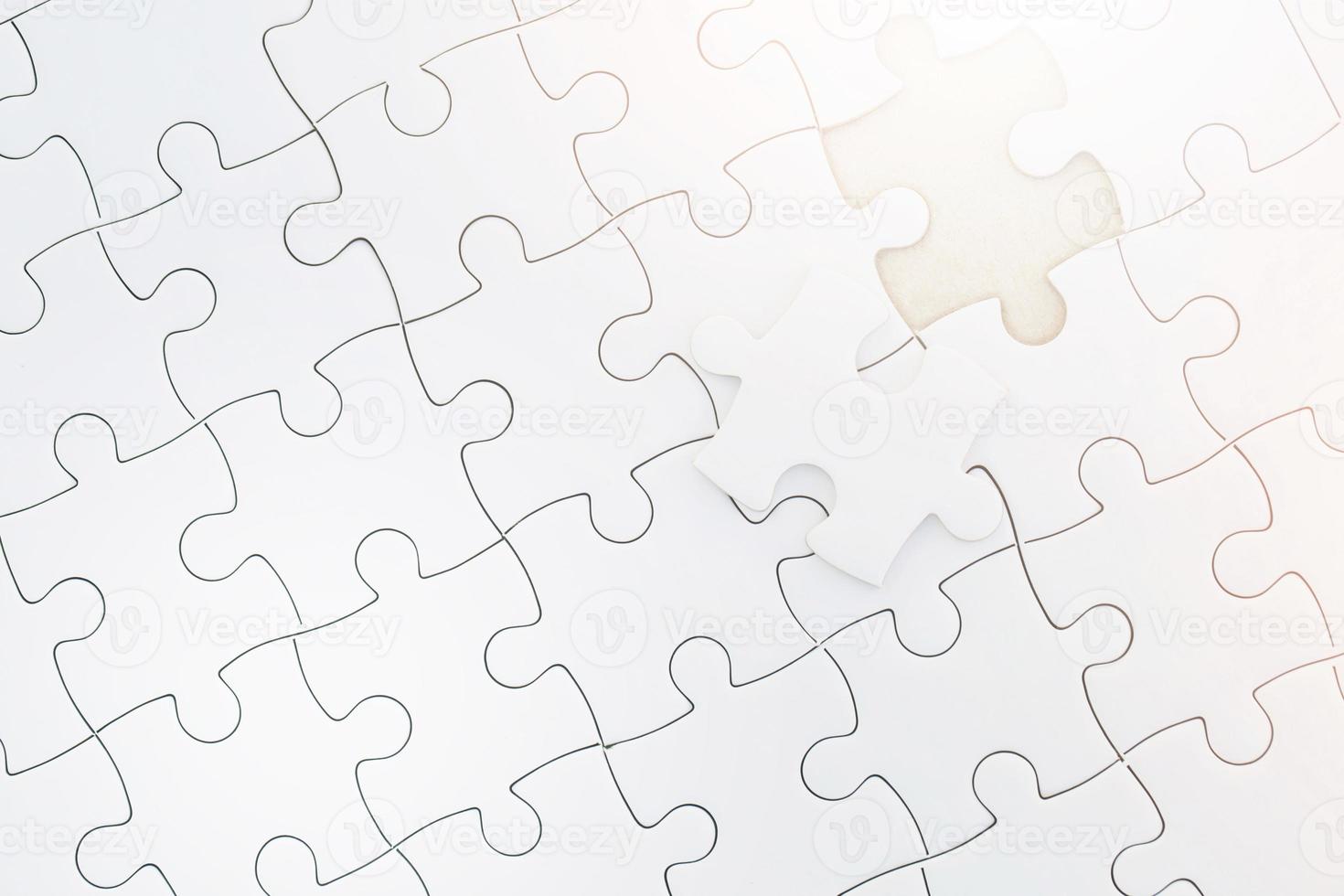 close up palm hand placed a last piece of the unfinished white jigsaw puzzle to the mission to make the completely finish,  Business solutions, success and project plan strategy concept. photo