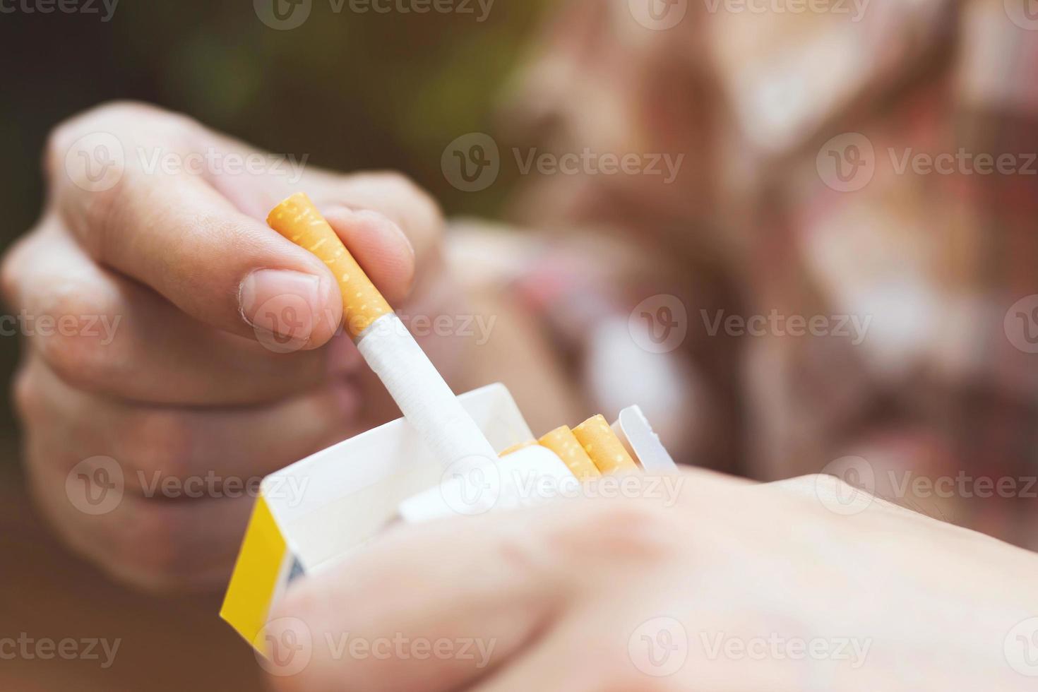 close up man hand holding peel it off cigarette pack prepare smoking a cigarette. Packing line up. photo filters Natural light.