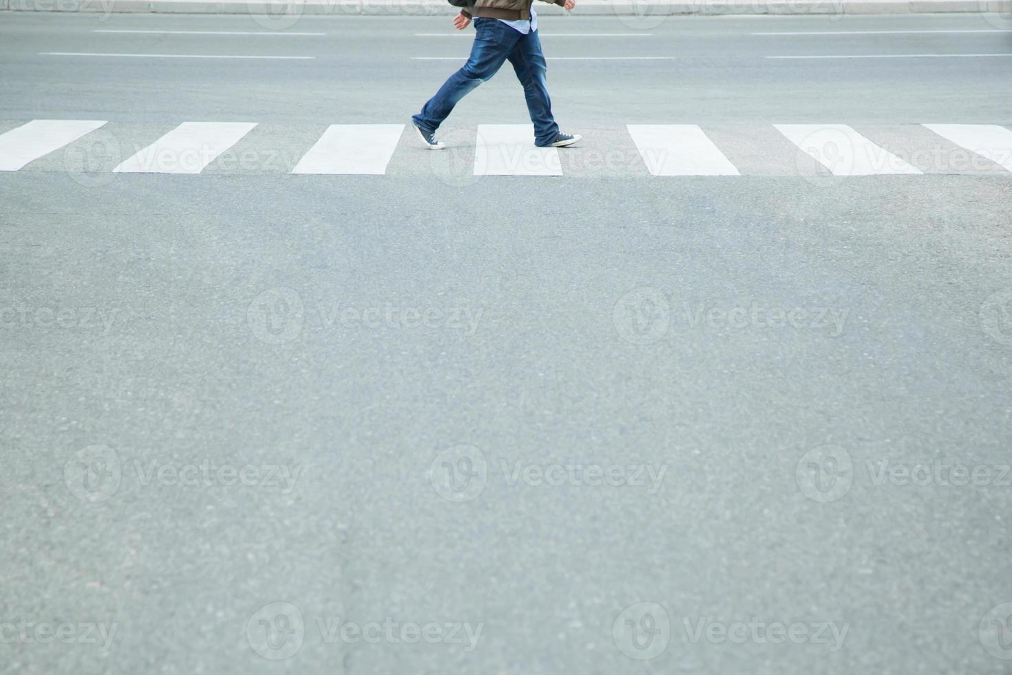 Tourist Man wear jeans walking with backpack across the crosswalk at the junction street of city, Pedestrian safety concept,  Leave space empty, write a message on the road. photo