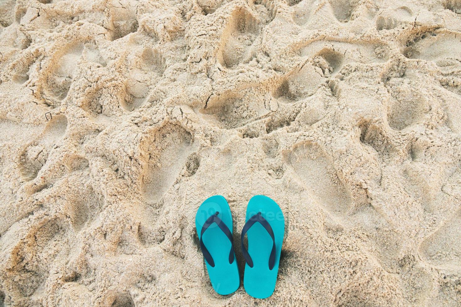 mar en la playa huella de personas en la arena y zapatilla de pies en sandalias zapatos sobre fondo de arena de playa. concepto de vacaciones de viaje. foto