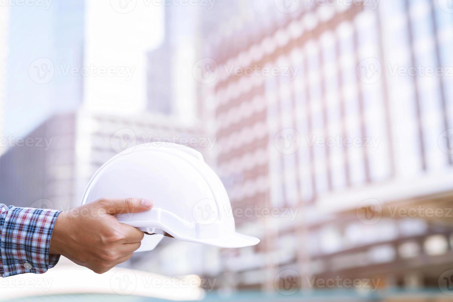 Construction safety engineer holding hard hat for safe work. Safety Suit Trust Team Holding White Yellow Safety hard hat Security Equipment on Construction Site. photo