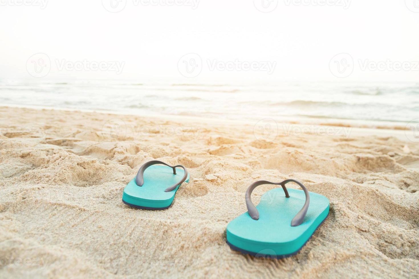 sea on the beach Footprint  people on the sand and slipper of feet in sandals shoes on beach sands background. travel holidays concept. photo