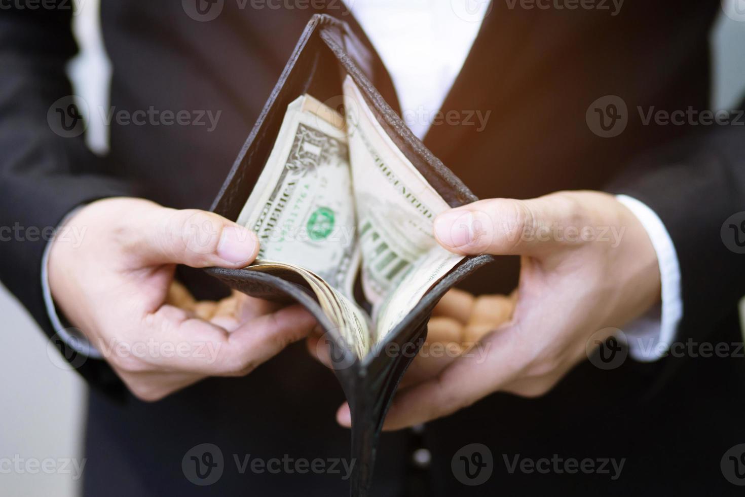 hombre de negocios que sostiene una billetera en manos de un hombre saca dinero de su bolsillo. foto