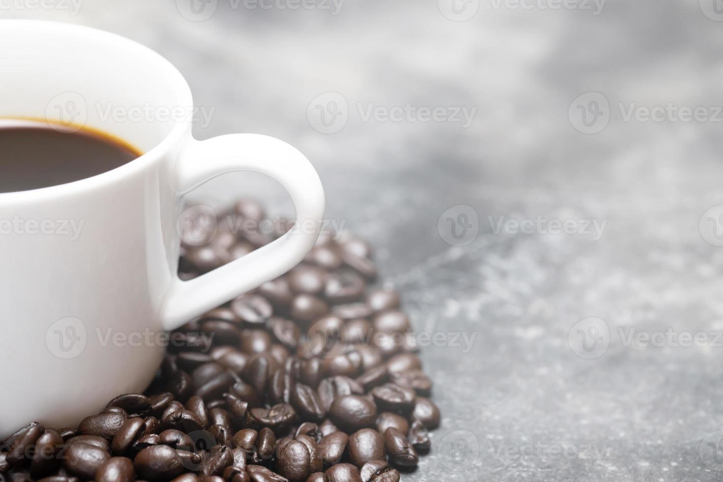 White coffee cup and coffee beans dark on table Bare mortar cement style loft background. soft focus. photo