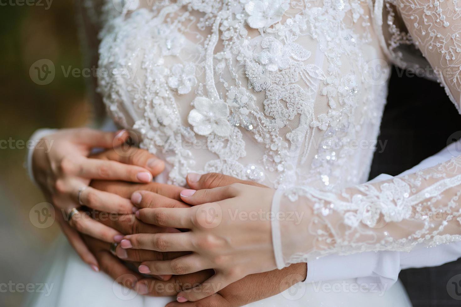 the bride and groom tenderly hold hands between them love and relationships photo