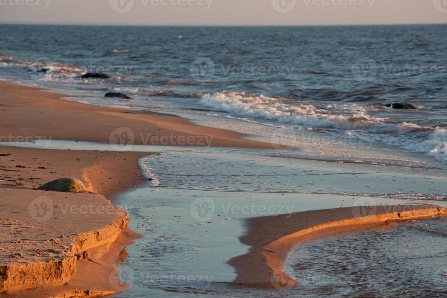 piedras en la costa del mar Báltico al atardecer foto