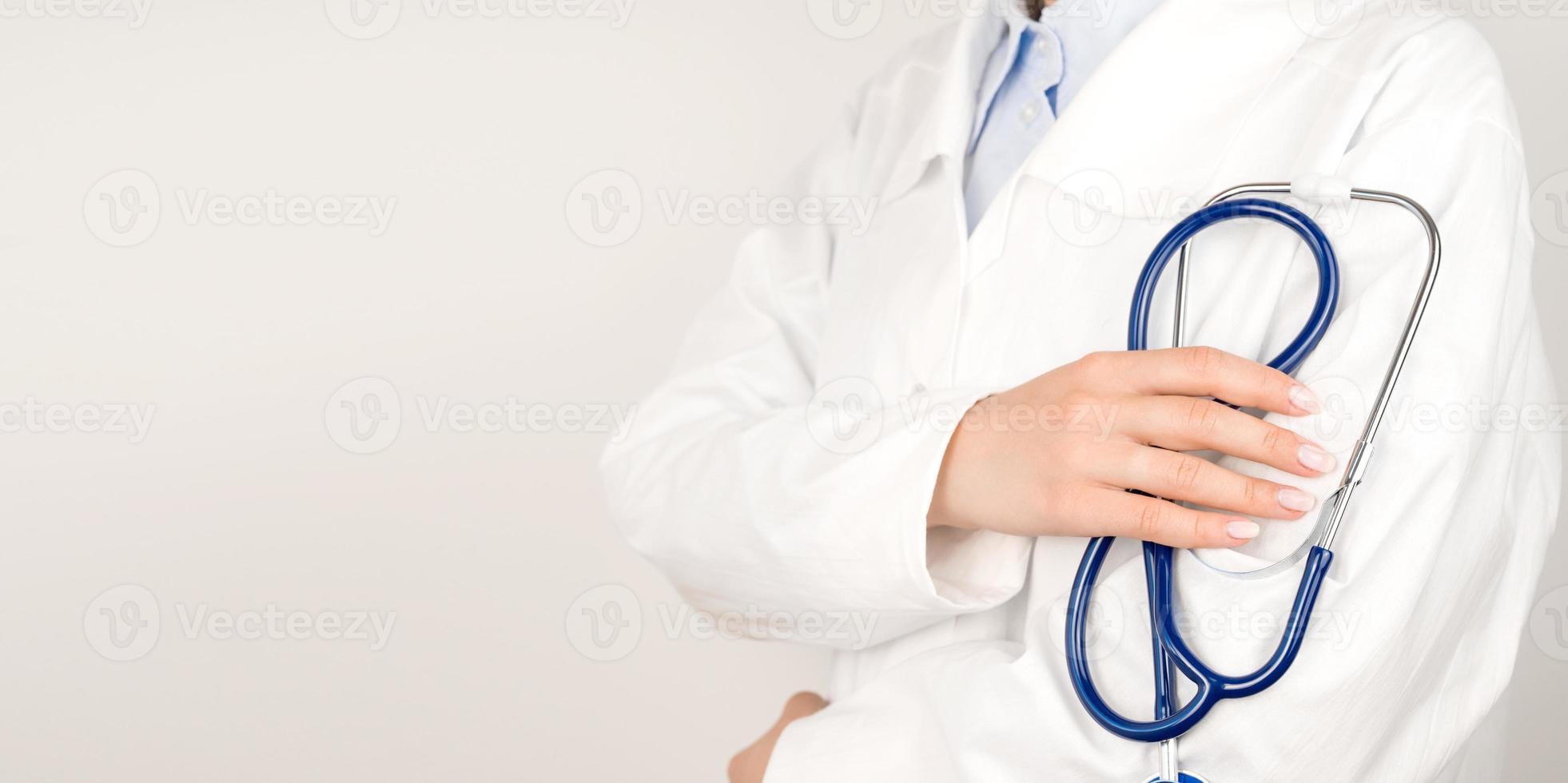 Healthcare concept panoramic banner.Unrecognizable doctor in white lab coat holding stethoscope in hands photo