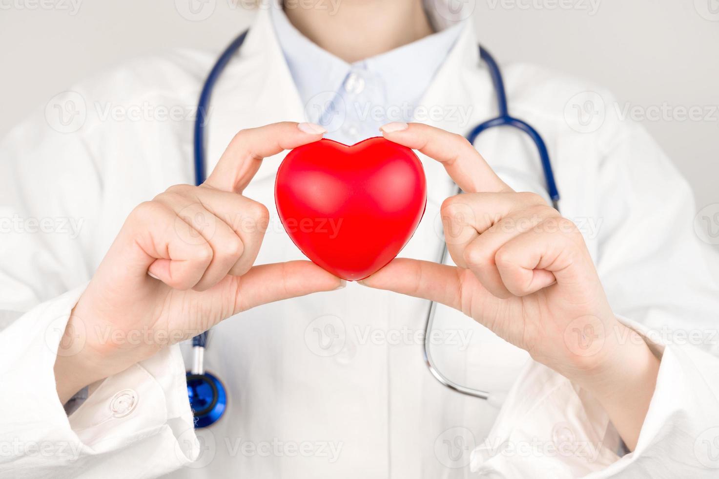 Unrecognizable doctor holding heart on table. Organ donations,charity,cardiology concept photo