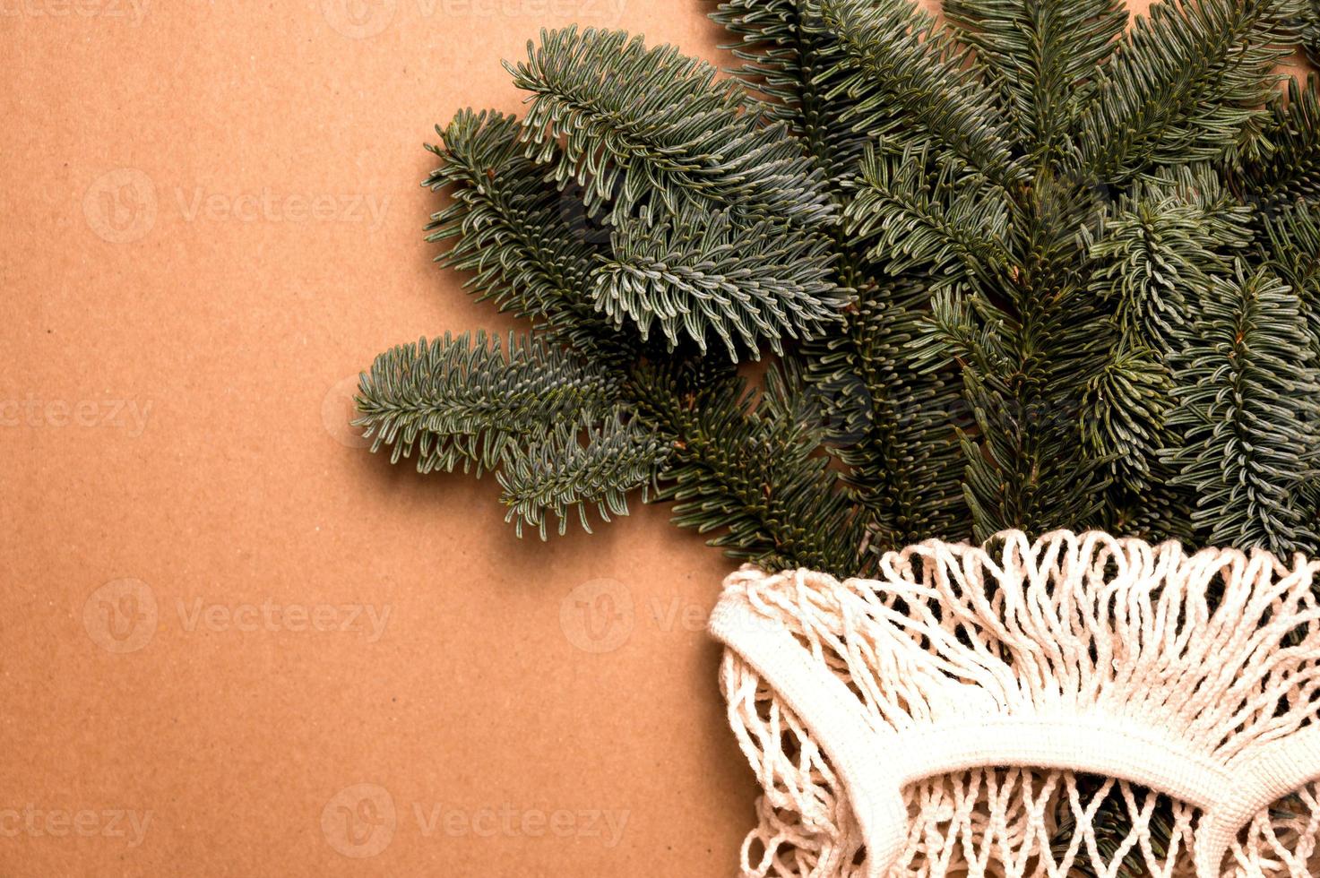 primer plano de ramas de abeto en bolsa ecológica. concepto de vacaciones de invierno sostenible y de residuos aerodinámicos.lugar para texto foto