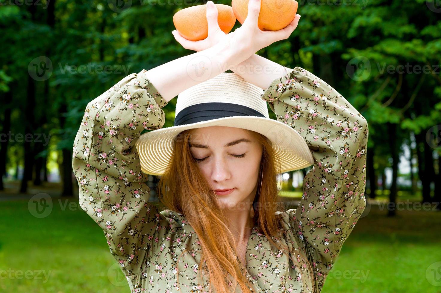 Young relaxed red haired girl with closed eyes having quiet moment outdoors photo