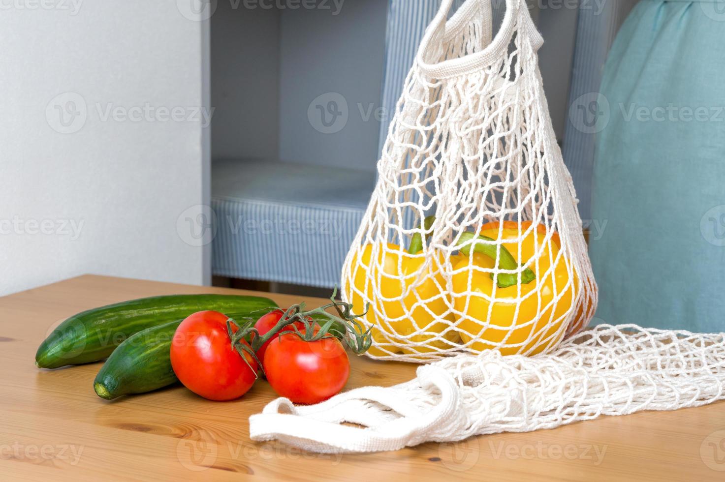 Closeup of a woman's hand holding eco-friendly shopper with fresh vegetables. Sustainable shopping concept.Healthy eating photo